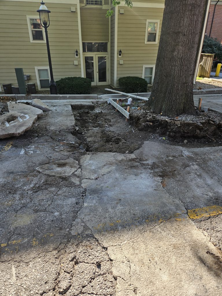 Parking lot with potholes next to building