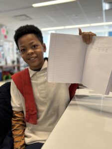 Student holding up his solved math problems