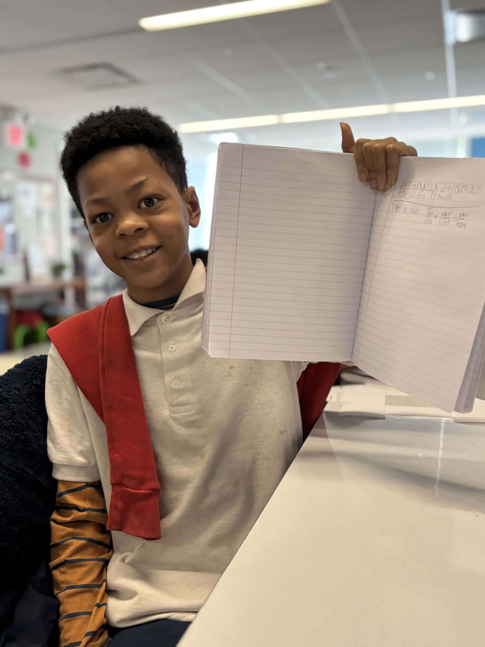 Student holding up his solved math problems