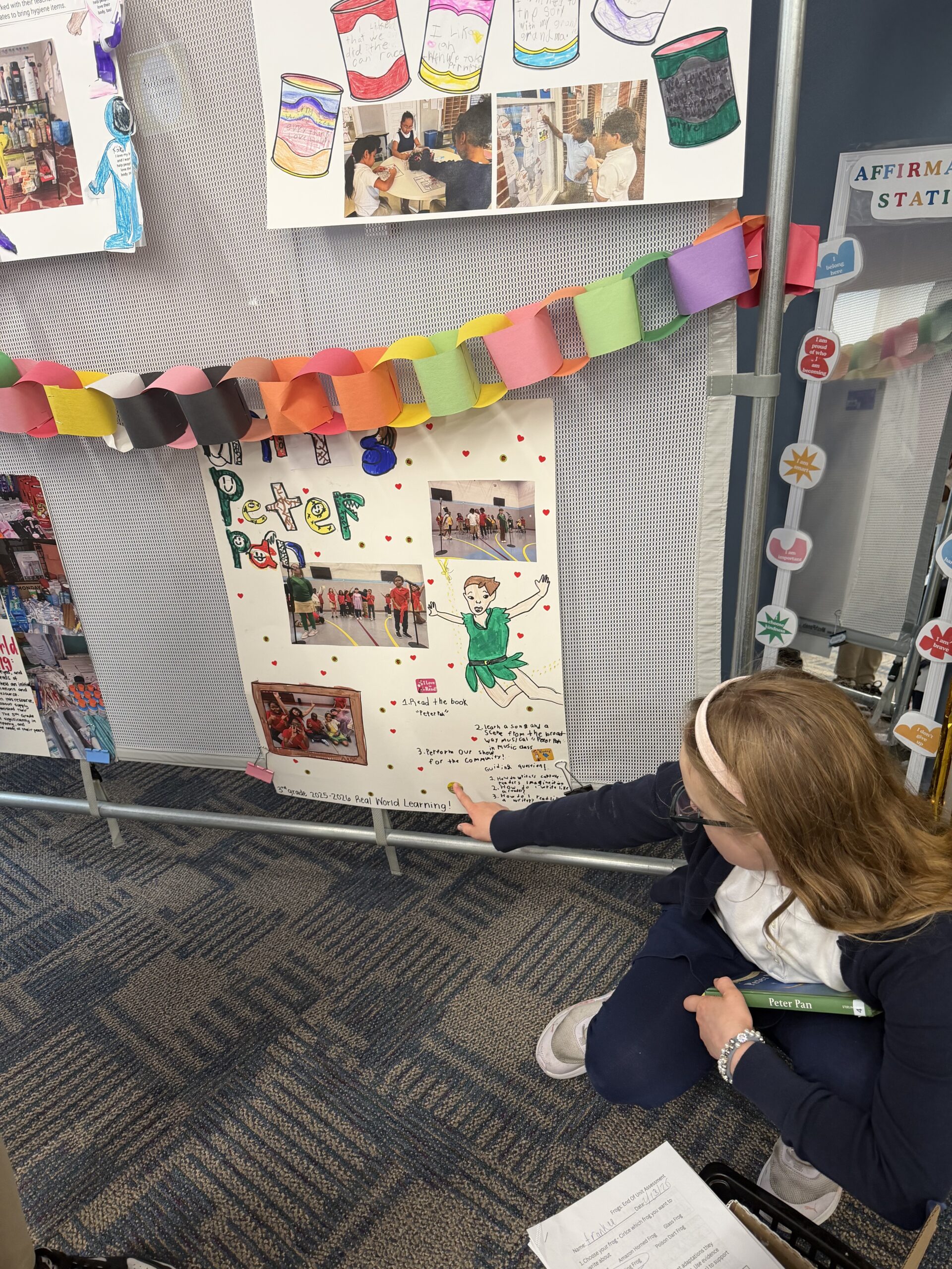 Student pointing at their work on a board