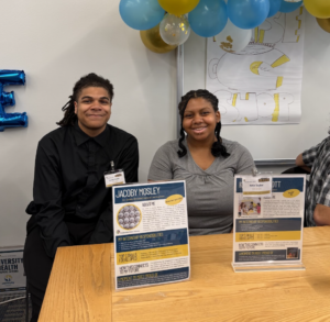 Students smiling while sitting at a table